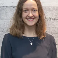 En kvinne som smiler til kameraet