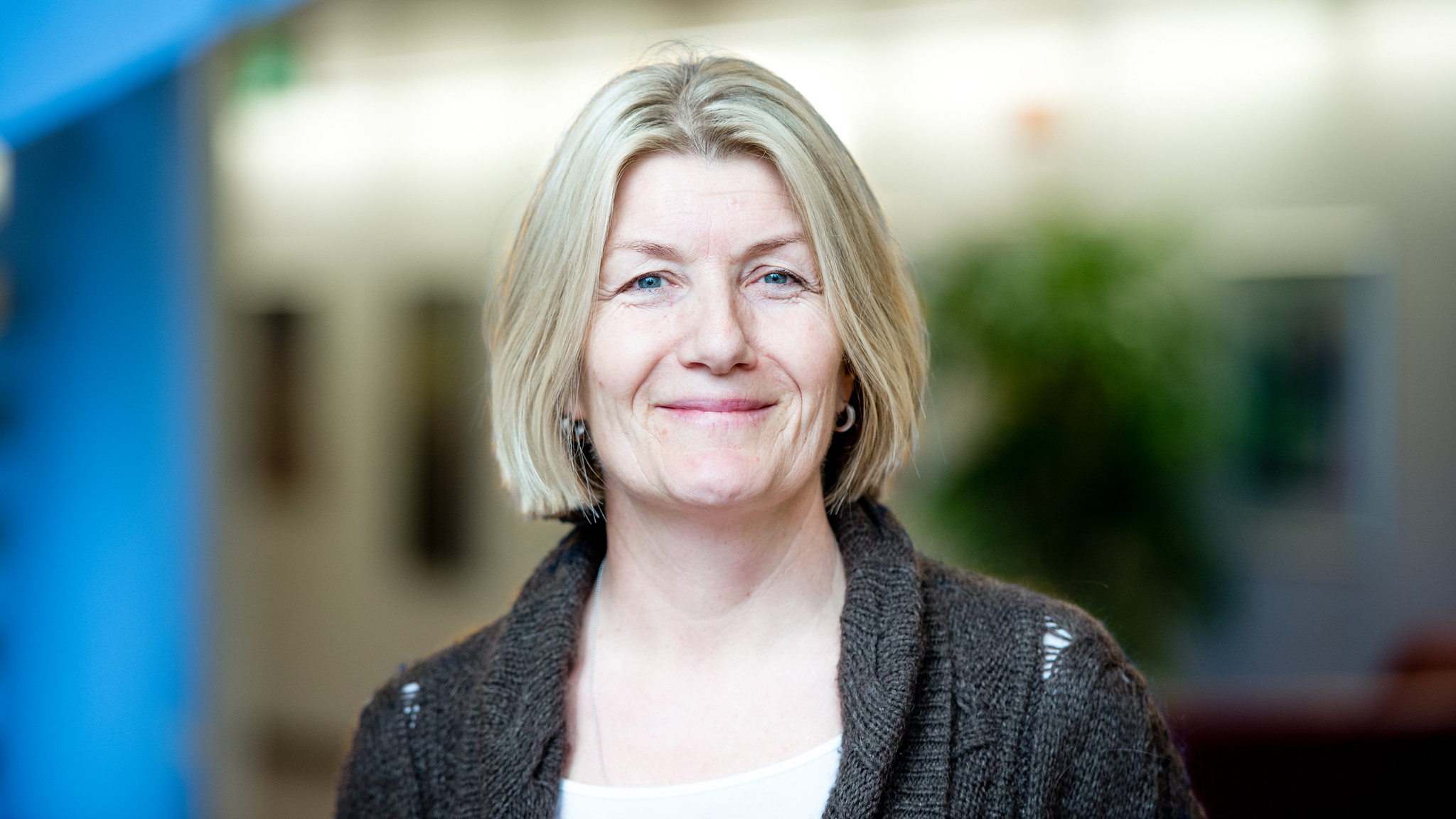 En kvinne som smiler til kameraet