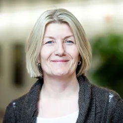 En kvinne som smiler til kameraet