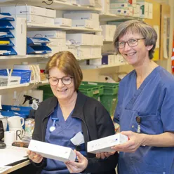 Et par kvinner holder papirer