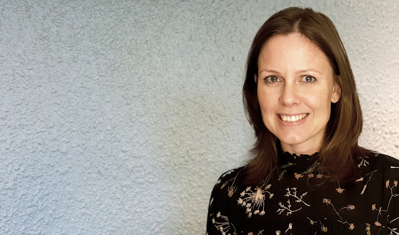 En kvinne som smiler til kameraet