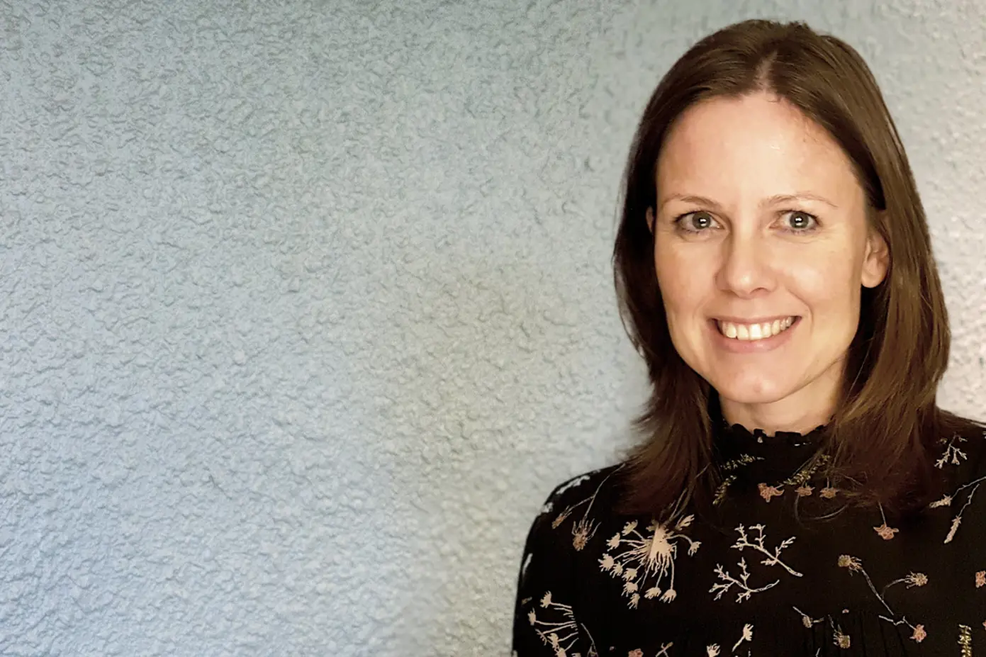 En kvinne som smiler til kameraet