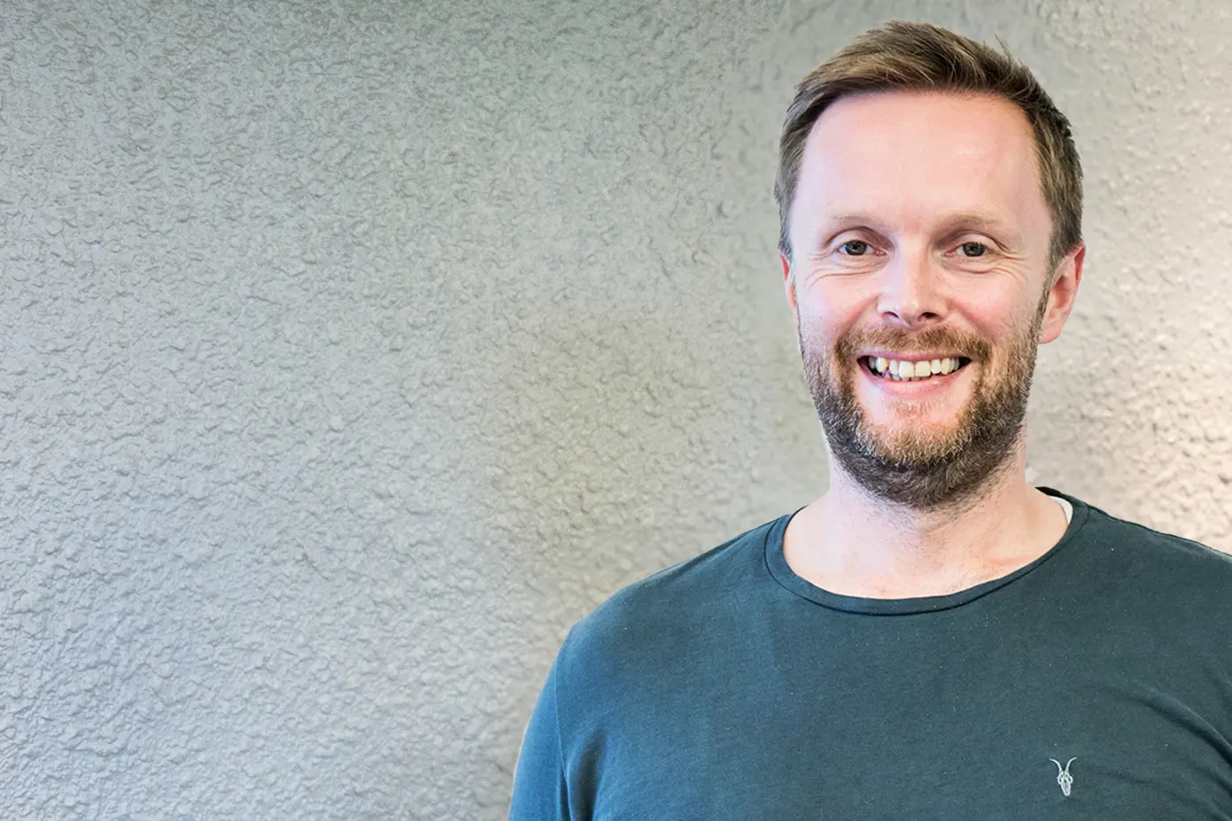 En mann som smiler til kameraet