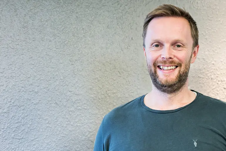 En mann som smiler til kameraet
