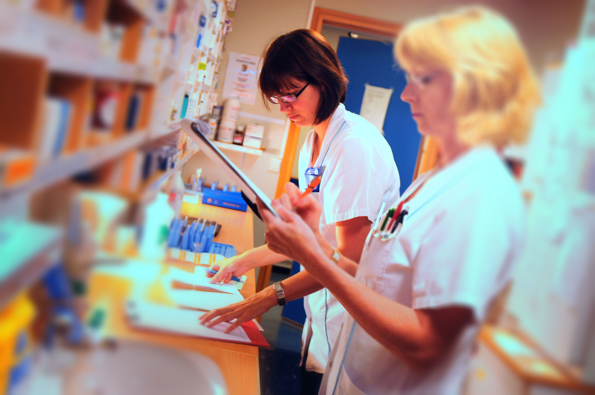 En lege som viser en pasient noe på datamaskinen