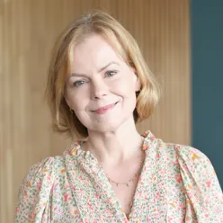 En kvinne som smiler til kameraet