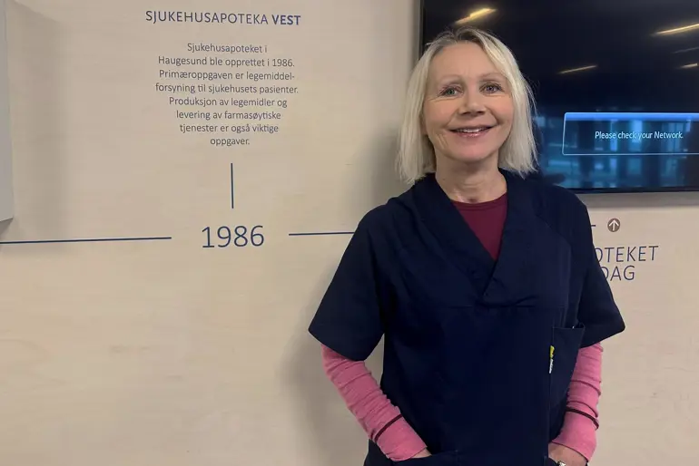 En kvinne som står foran et skilt