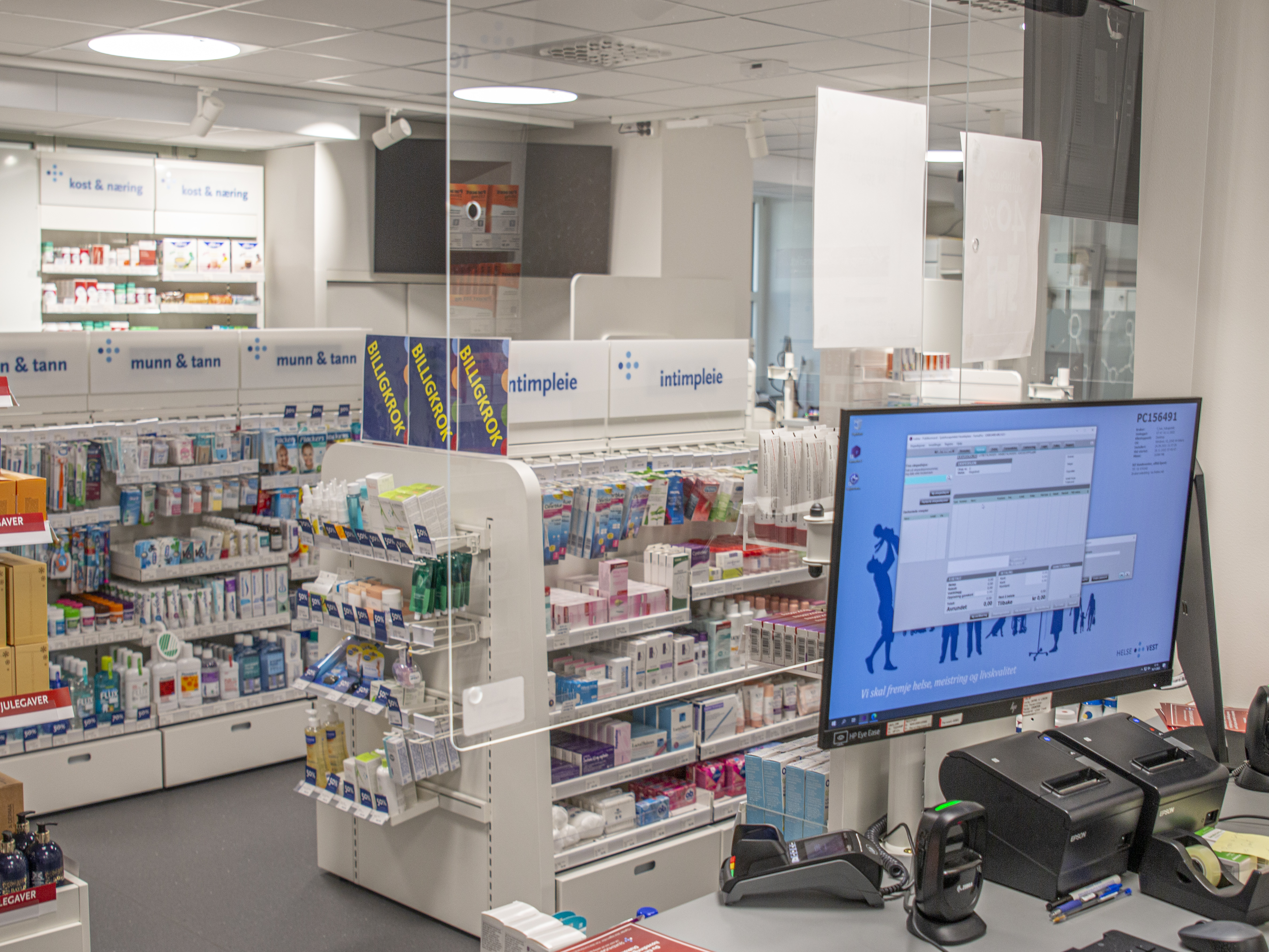 Vi ser et tomt apotek, uten kunder, men med hyller fulle av varer.