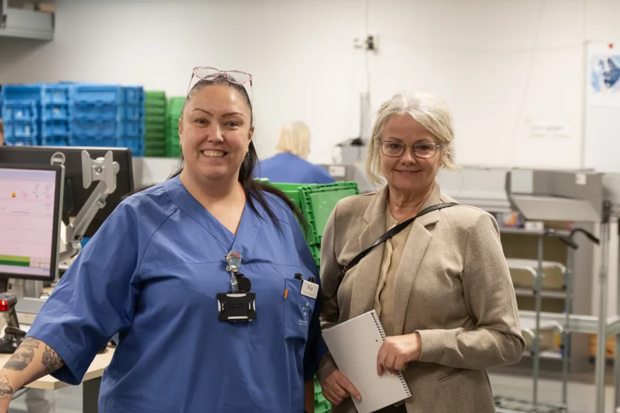 Silje Beuster og Tove Kittelsrud poserer for kamera foran plukkavdelingen på sykehusapoteket i Bergen.