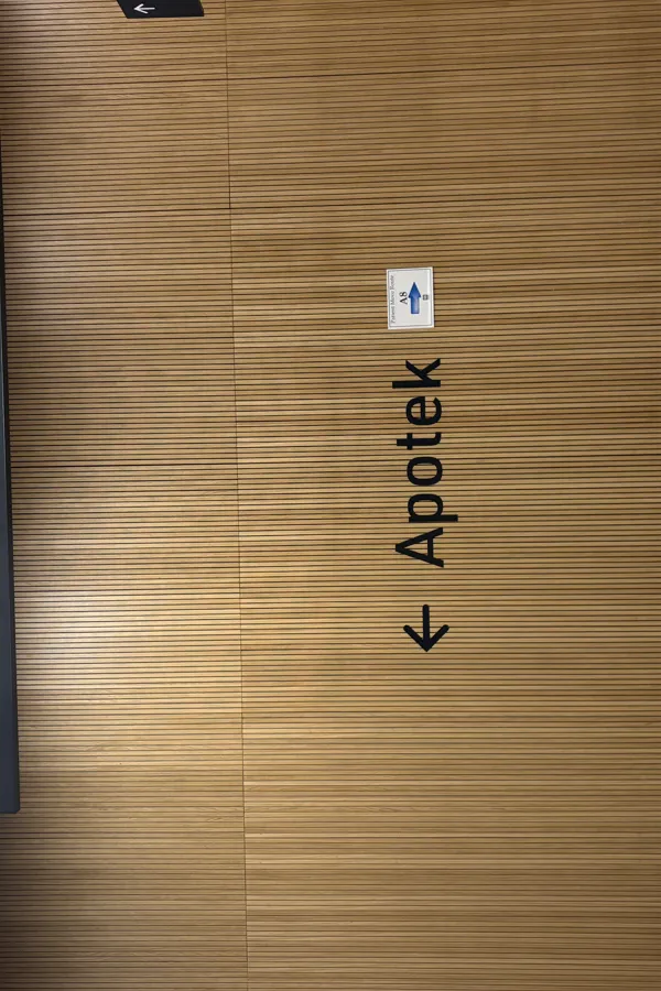 Skilt til apoteket på spilevegg av eik.