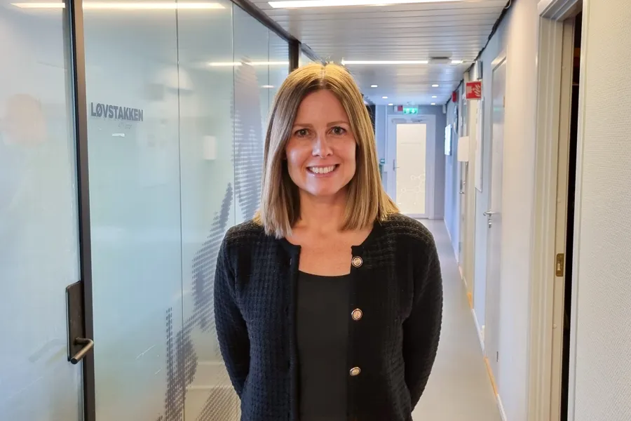 En kvinne som smiler i gangen